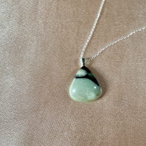 Teardrop-shaped green gemstone pendant necklace with dark swirling natural inclusions, likely jade or prehnite, elegant crystal jewelry piece.